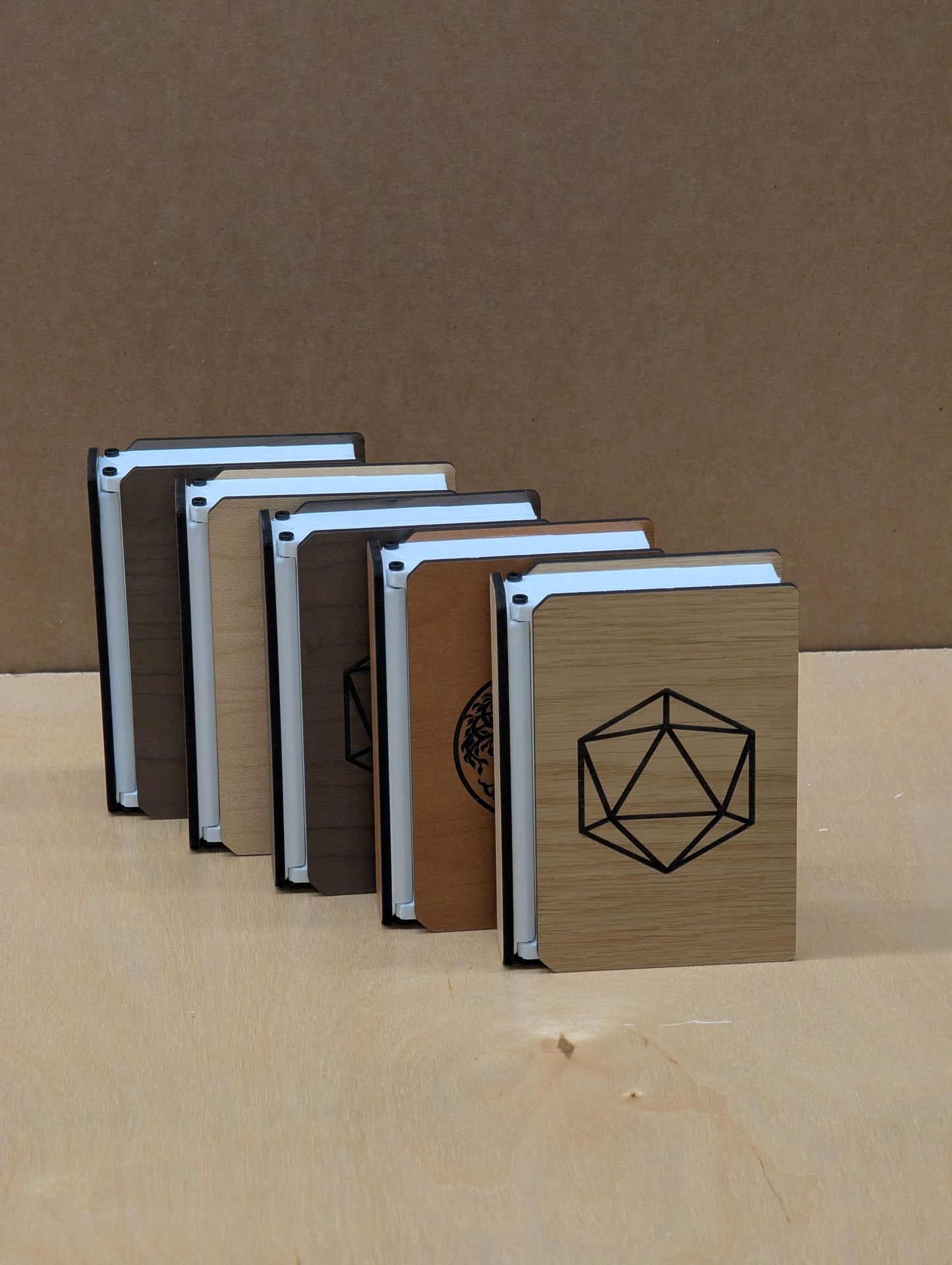 Set of four notebooks with different covers and designs on a brown background