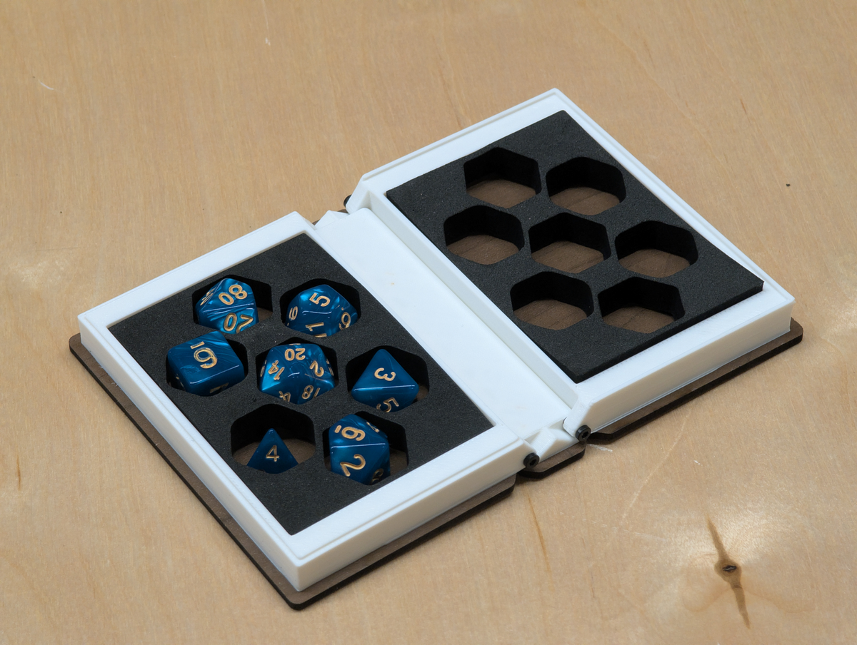 Set of blue dice with gold numbers in an opened box designed like a book.