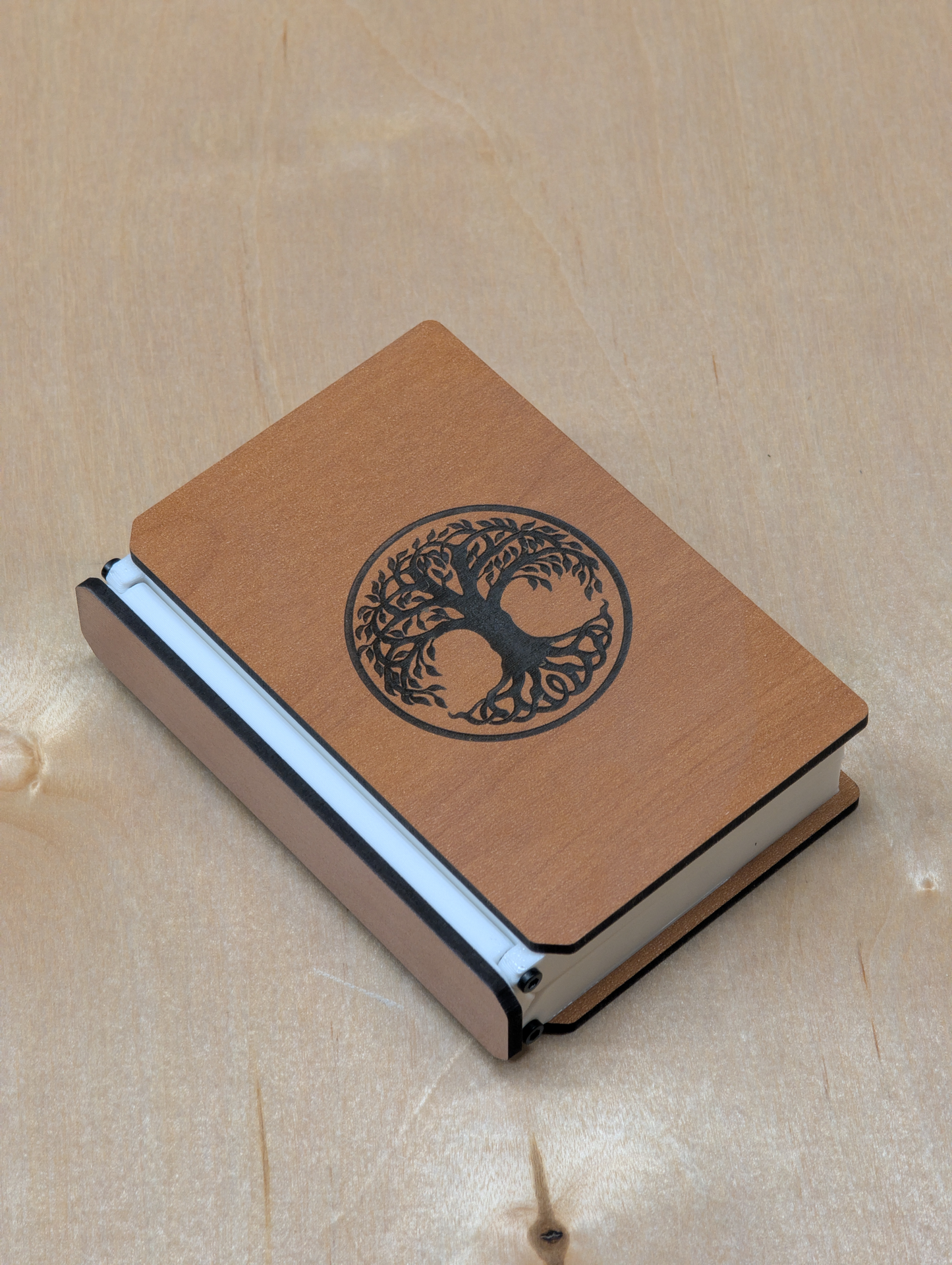 Wooden notebook with tree of life design on a beige background